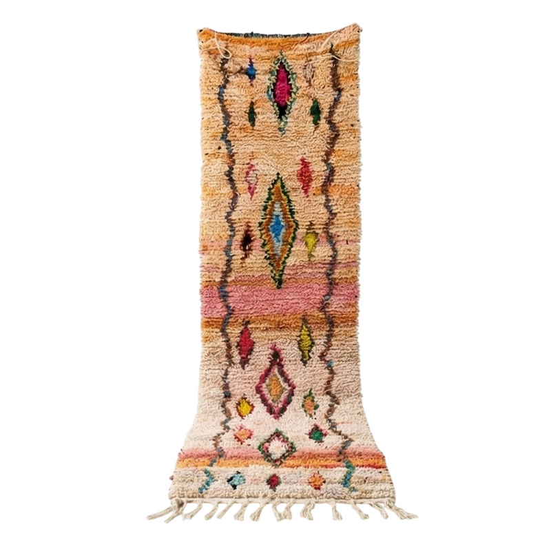 Tapis berbère shaggy crème avec motifs losanges colorés, bandes roses et franges.