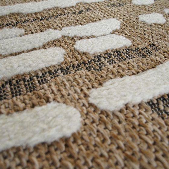 Tapis en jute marron clair en relief avec motifs blancs épais et fines rayures noires tissées.