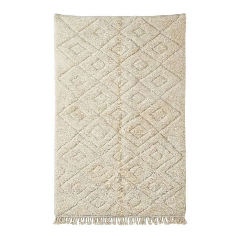 Grand tapis berbère beige à motif losanges imbriqués, de texture moelleuse et à franges.

