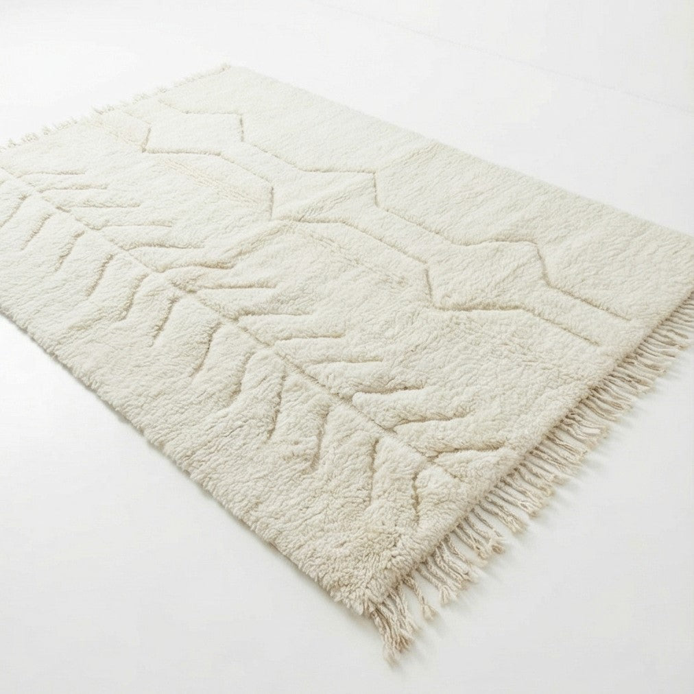 Tapis en laine crème doux avec motif géométrique et franges, parfait pour une décoration intérieure moderne.