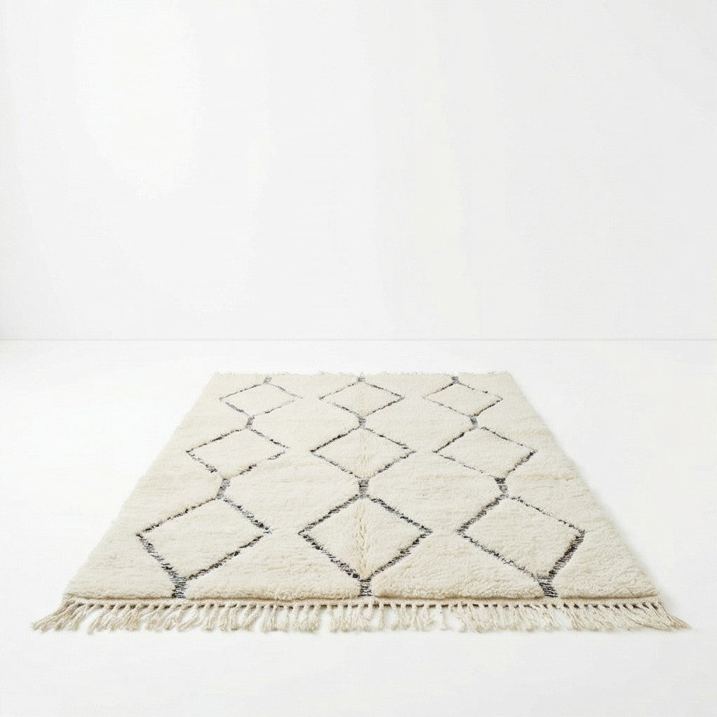 Tapis Beni Ouarain blanc à motifs losanges, de longs poils et franges décoratives.
