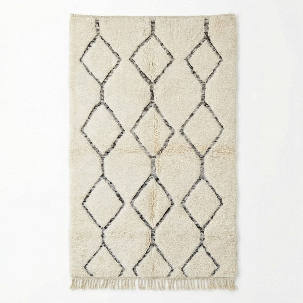 Tapis Beni Ouarain blanc cassé à motifs losanges creux, de style berbère, avec des franges.

