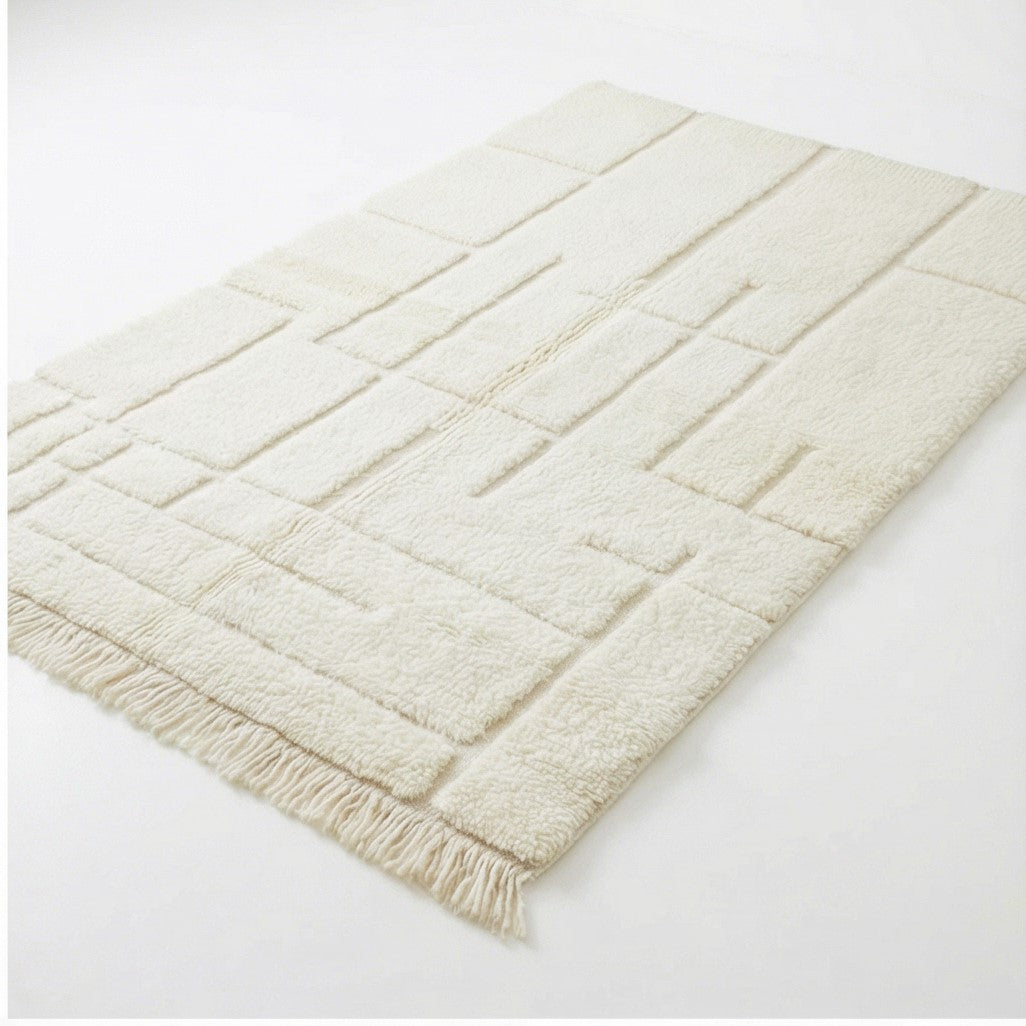 Tapis berbère graphique blanc, 150x250 cm, avec un motif géométrique en relief et des franges décoratives.
