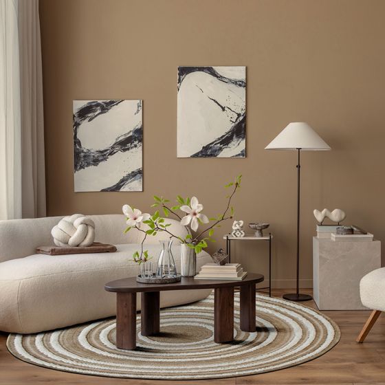 Tapis rond en jute naturel beige à motifs de cercles concentriques clairs, sur un parquet de salon.