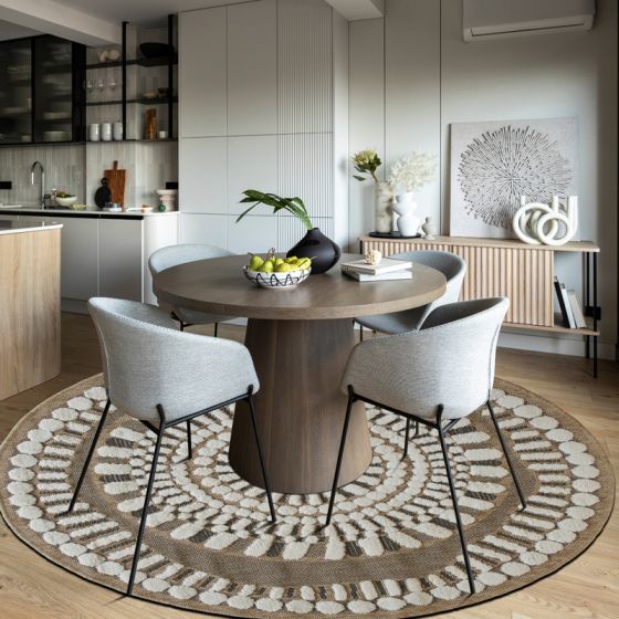 Tapis rond en jute naturel avec des motifs circulaires en relief blancs.